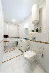 y baño blanco con aseo y ducha. en Уютная 1 комнатная квартира Люкс на Теремках, en Kiev