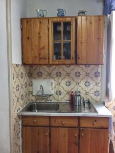 una cocina con armarios de madera y fregadero en Ribeira da Praia House, en Vila Franca do Campo