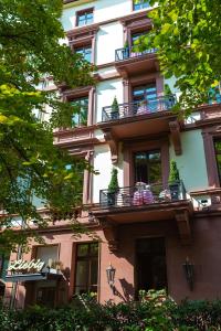 un edificio con balcones y personas sentadas en ellos en Hotel Liebig, en Frankfurt