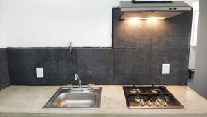 a kitchen counter with a sink and a stove at Dep Aurora by Hansa AC Wifi 5 min de playa in Puerto Vallarta