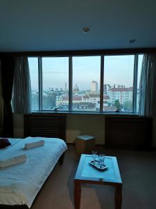 um quarto de hotel com duas camas e uma mesa com copos em Panorama Apartman em Novi Sad