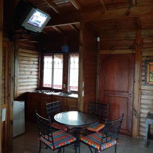 a dining room with a table and chairs and a television at Horizonte del Quindío - Chalet privado in Quimbaya