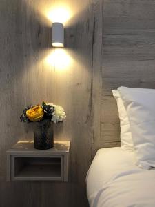 um vaso de flores em uma mesa ao lado de uma cama em McNaughton Guestrooms em Ballymena