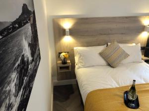a bedroom with a white bed with a wooden headboard at McNaughton Guestrooms in Ballymena