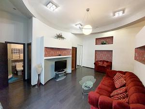 キーウにあるInn Home Apartments - Pechersk areaのリビングルーム(赤いソファ、暖炉付)
