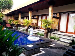 a resort with a fountain in the middle of a pool at Kamboja Homestay in Sanur