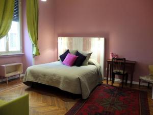 a bedroom with a bed with pink walls and a red rug at Dimora Al 36 in Rome