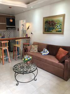 a living room with a brown couch and a table at Apartamento 05 Vivendas do Serrano - Lençóis in Lençóis
