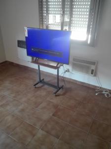 TV de pantalla plana sentada en un stand en una habitación en Andes 1 en Mendoza