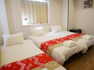 two beds in a small room with a window at Tokyo shinjukutei Hotel Asahi gruop 東京新宿亭ホテル in Tokyo