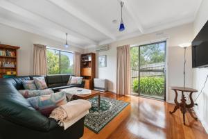 a living room with a couch and a table at Blairgowrie Beach Baby in Blairgowrie