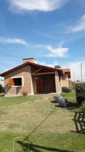 a house with a hose in front of a yard at Cabañas De Cara al Sol in Villa Giardino