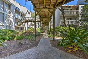 a walkway in front of a building with a pergola at Coastal Oasis with Pool - Walk to Coligny Beach Park in Hilton Head Island