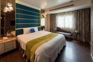 a bedroom with a large bed and a desk and window at 伊都旅店 Motel in Dacun