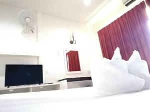 タラーンにあるAndaman Placeのベッドとテレビが備わるホテルルームです。