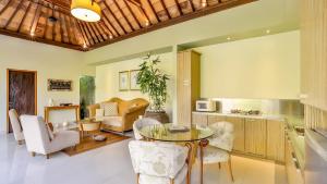 a living room with a table and chairs at DISINI Luxury Spa Villas-CHSE Certified in Seminyak