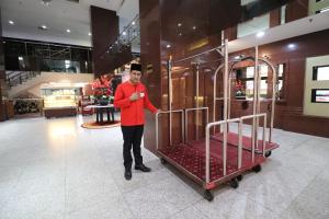 un hombre parado junto a una cama en una tienda en Hotel Grand Continental Kuala Lumpur en Kuala Lumpur