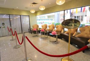 uma sala de espera com cadeiras e uma fita vermelha em Hotel Grand Continental Kuala Lumpur em Kuala Lumpur
