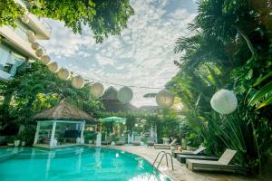 a swimming pool in a resort with chairs and lights at Bali Mystique Hotel & Apartment in Seminyak