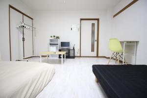 Jest to biały pokój z łóżkiem, biurkiem i krzesłem. w obiekcie Frere Shichijo w mieście Kioto