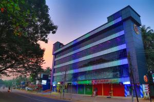 ein großes Gebäude mit bunten Fenstern auf einer Stadtstraße in der Unterkunft karibu Residency in Malappuram