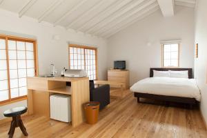 a bedroom with a bed and a sink in it at Machiya no Yado Iroha in Nagahama