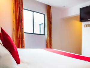 a bedroom with a bed with red pillows and a window at Hotel SR92 Adults Only in Mexico City