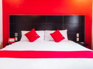 a red and white bed with red pillows on it at Hotel SR92 Adults Only in Mexico City
