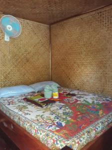 a bed in a room with a table on it at Castaway Native Huts in San Vicente