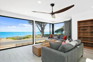 sala de estar con sofá y ventilador de techo en Apollo Bay Beach House, en Apollo Bay