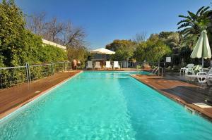 einen großen blauen Pool mit Holzterrasse in der Unterkunft איתן בקתות עץ Eitan Wood Cabins Resort in Sede Eli‘ezer