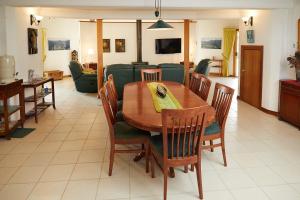 een eetkamer met een houten tafel en stoelen bij A view of Mount Warning in Uki