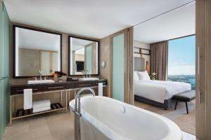 
a hotel room with a large tub and a large mirror at Sofitel Sydney Darling Harbour in Sydney
