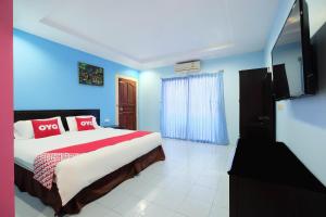 1 dormitorio con cama y pared azul en OYO 609 Lanta Dream House Apartment en Ko Lanta