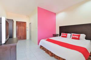 Un dormitorio con una cama grande y una pared rosa en OYO 609 Lanta Dream House Apartment en Ko Lanta