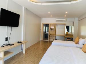 two beds in a room with a flat screen tv at Cheow Lan Easy Home in Ban Tha Khun