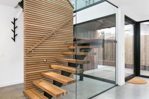 a wooden staircase in a house with a glass wall at Apollo Bay Beach House in Apollo Bay