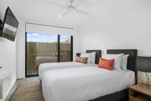 a bedroom with two beds and a balcony at Apollo Bay Beach House in Apollo Bay