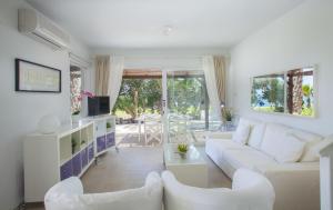 ein Wohnzimmer mit einem weißen Sofa und Stühlen in der Unterkunft Napa Beachfront Villa in Ayia Napa