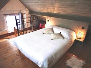 a bedroom with a large white bed with two pillows at La cabane du chasseur in Flines-lès-Mortagne