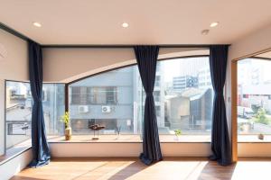 a room with large windows with black curtains at TORA HOTEL Tokyo Skytree 寅ホテル スカイツリーC in Tokyo