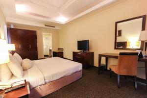 a hotel room with a bed and a desk at Harmoni One Convention Hotel and Service Apartments in Batam Center