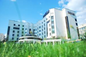 a grassy field with a large building at Park Inn by Radisson in Yekaterinburg