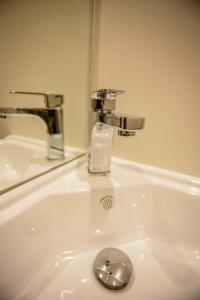 a bathroom sink with a faucet and a mirror at Southern Cross Lodge Methven in Methven