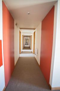 an empty corridor in an office building with orange and white walls at Southern Cross Lodge Methven in Methven