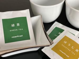 a book sitting on top of a table next to cups at Hotel Trusty Osaka Abeno in Osaka