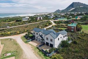 an aerial view of a house on a hill next to the ocean at Stay At Friends in Bettyʼs Bay