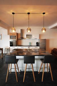 a kitchen with a large kitchen island with chairs at Lagadin Lakeview Apartment in Ohrid