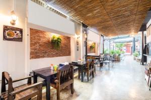 un restaurante con mesas y sillas y una pared de ladrillo en Baan Lanna at Prasingh, en Chiang Mai