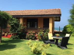 a house with a table and chairs in the yard at E-Beach Resort in Negombo